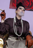 Курящая мамка в кожаных перчатках позирует на леопардовом кресле 7 фотография